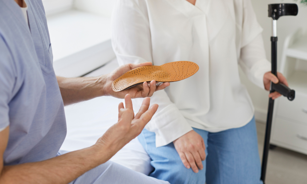 a pair of orthotics next to doctor with hands around a medical case to answer are orthotics covered by insurance