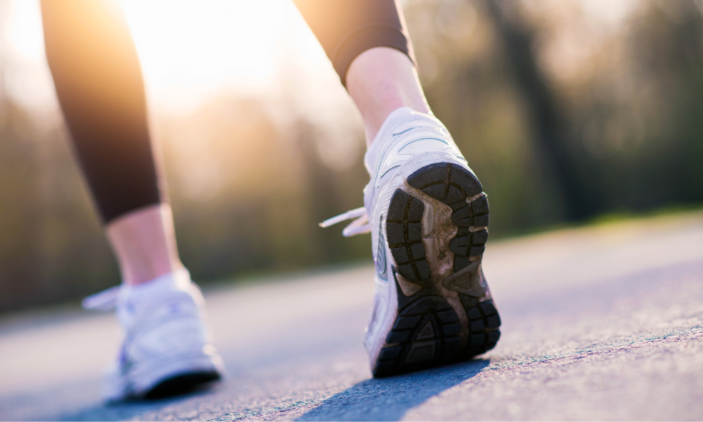 A woman walking, featuring a closeup of the wear on her shoe soles, which can tell you if you have foot supination vs pronation.